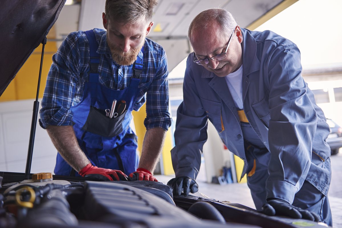 Dvaja mechanici Maranello Servis pri práci na motore